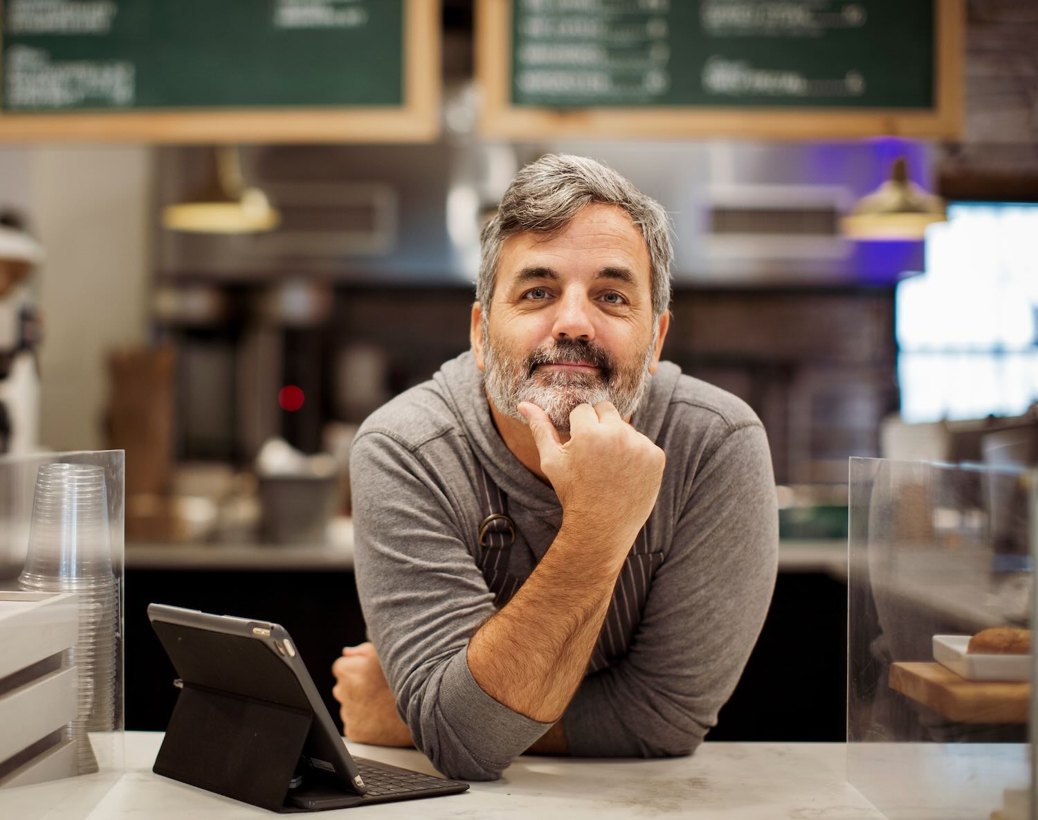 Business owner standing behind the counter in this coffeshop 