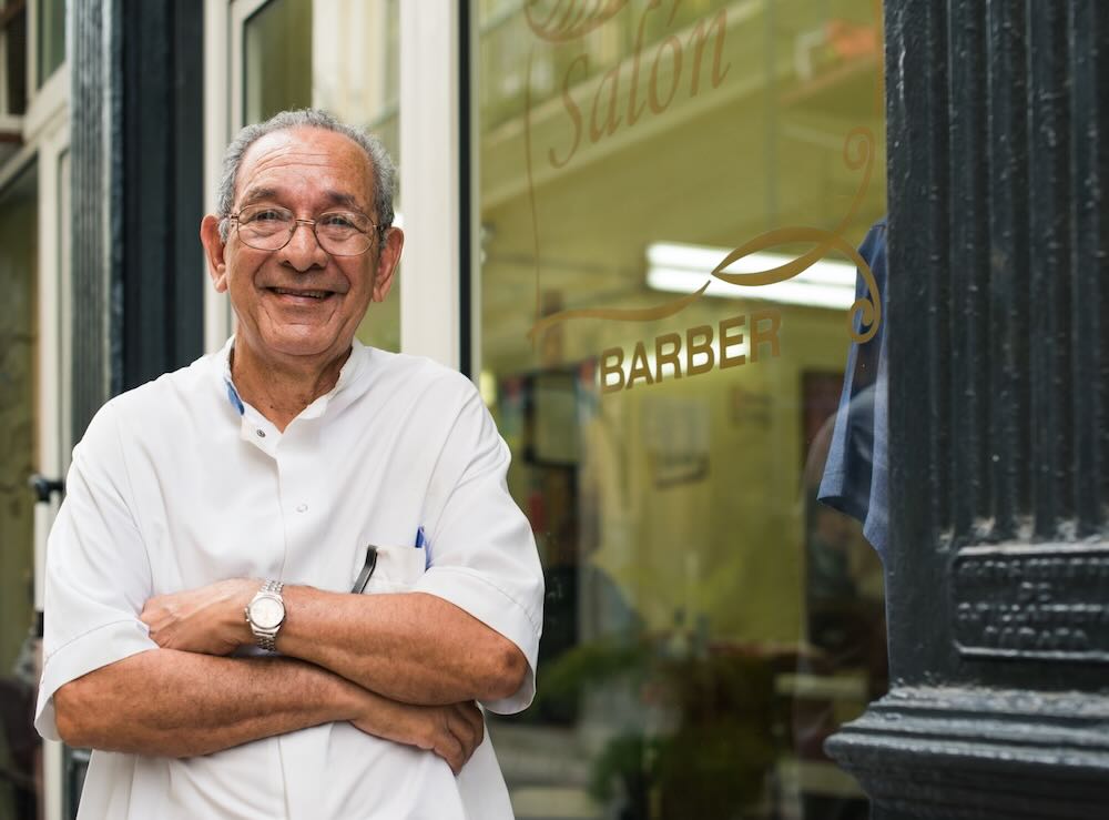 Business owner in front of his barbershop 