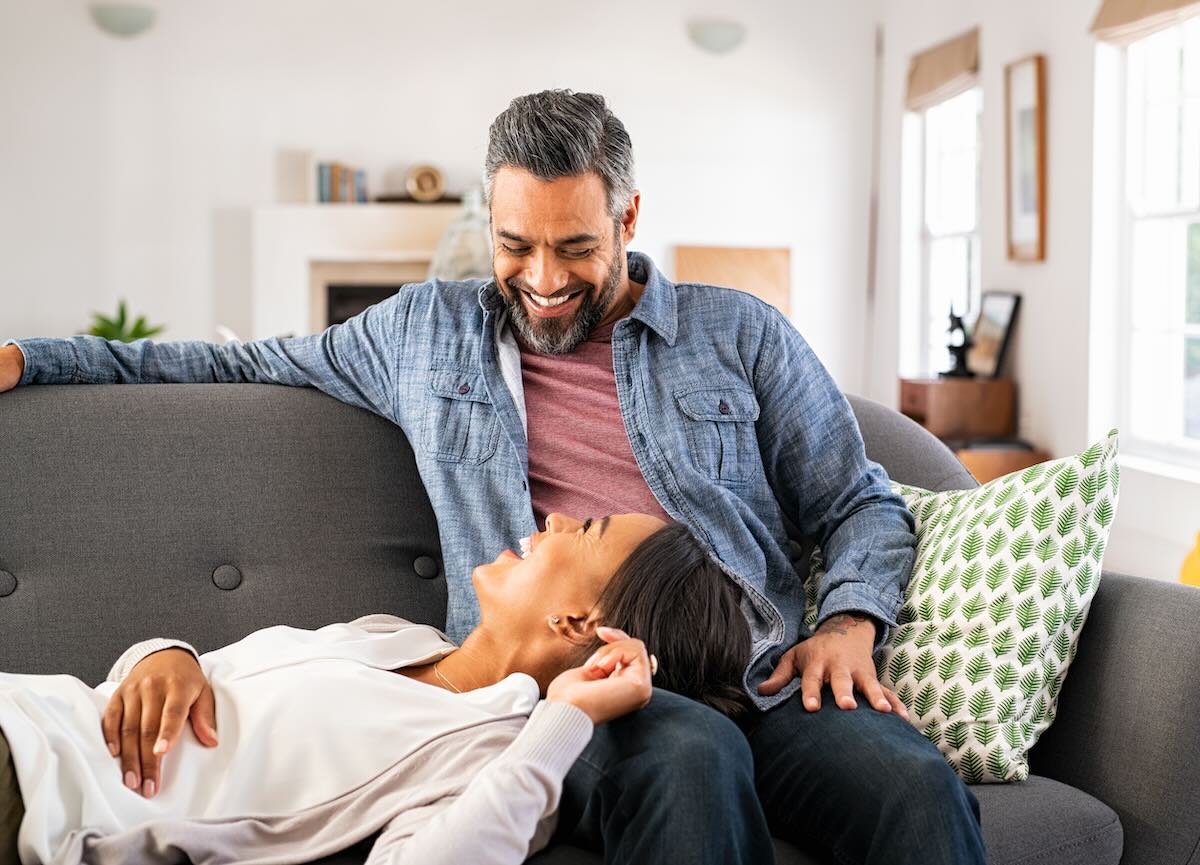 Joyful couple relax together at home